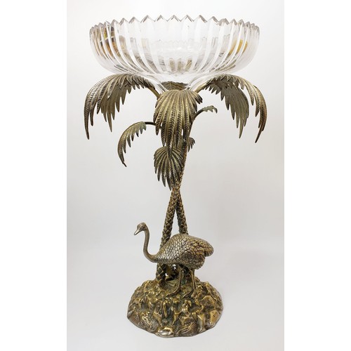 451 - An antique silver plated table centre piece modelled as an Ostrich beside palm trees with a cut glas... 