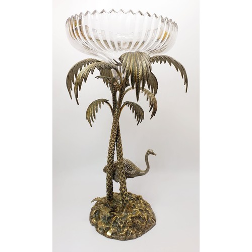 451 - An antique silver plated table centre piece modelled as an Ostrich beside palm trees with a cut glas... 