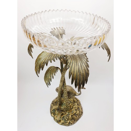 451 - An antique silver plated table centre piece modelled as an Ostrich beside palm trees with a cut glas... 