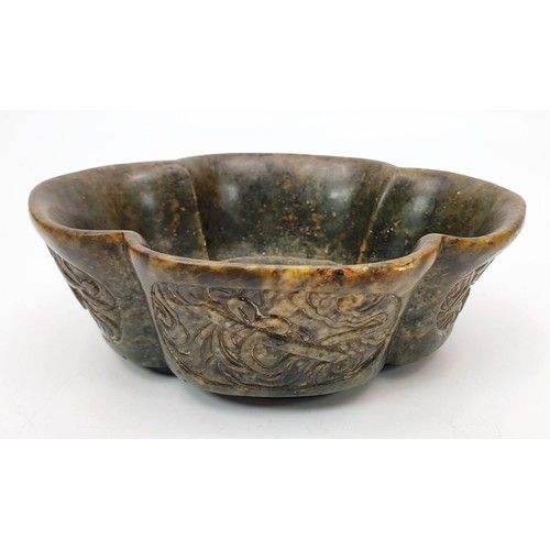 324 - A Chinese hard stone dish with carved panels bearing Buddhist emblems, length 5.5