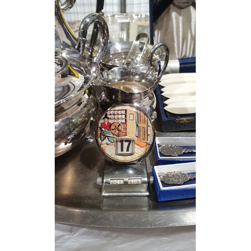15 - A four piece silver plated tea set, cased flatware and a desk calendar. UK shipping £14.