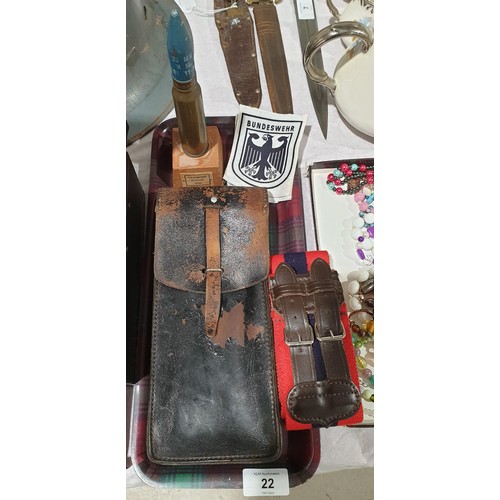 22 - A mounted shell, military belt and other assorted military items. UK shipping £14.