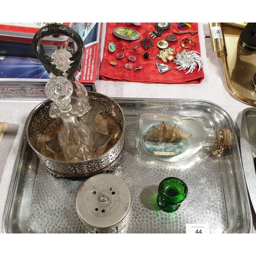 44 - A silver plated condiment holder with two bottles, a ship in a bottle, a money box and an eye bath. ... 