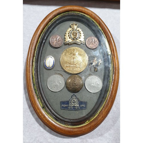 5 - A selection of Royal Canadian Mounted Police coins and badges in a wooden oval frame, length 7.25