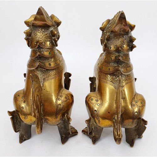 200 - A pair of antique brass Burmese mythical Chinthe inlaid with green glass, height 7.5