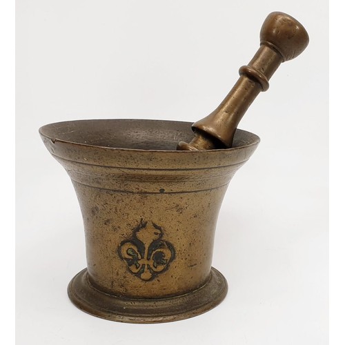 11 - An antique bronze pestle and mortar with fleur de lis motifs, height 4