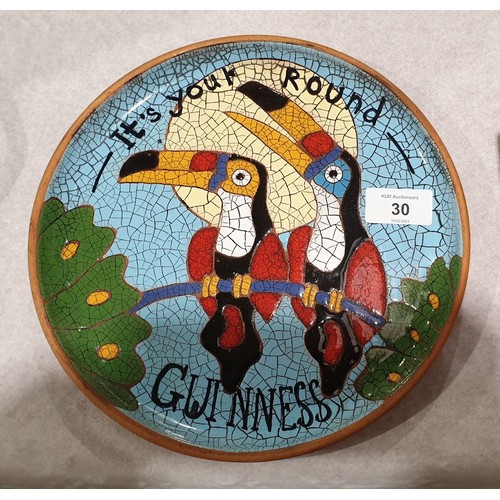 30 - A terracotta plate decorated in enamels with Guinness toucans and inscribed 