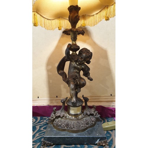 409 - A spelter table lamp in the form of a Putti on a marble base, height  29