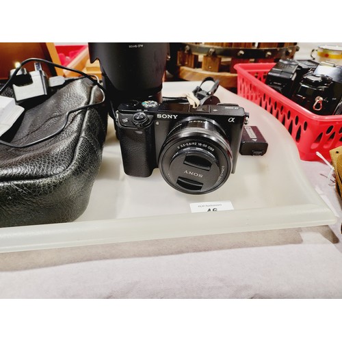 46 - A Sony A6000 camera together with three lenses and accessories. UK shipping £14.