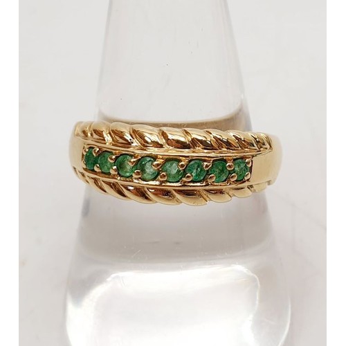 22 - A 9ct gold ring set with emeralds, size R/S, gross weight 3.5g. UK shipping £14.