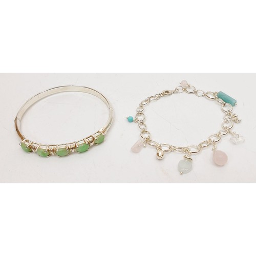 33 - A silver bangle set with green stones together with a silver stone charm bracelet, gross weight 24g.... 