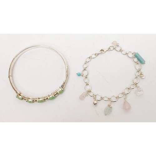 33 - A silver bangle set with green stones together with a silver stone charm bracelet, gross weight 24g.... 