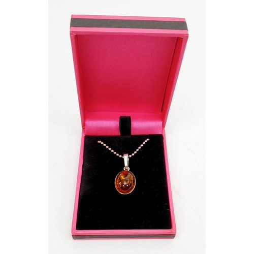 34 - A silver pendant set with amber on a silver chain. UK shipping £14.