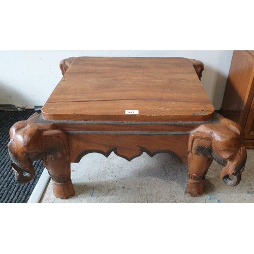 412 - A carved wooden coffee table with elephant's heads at the corners, 27