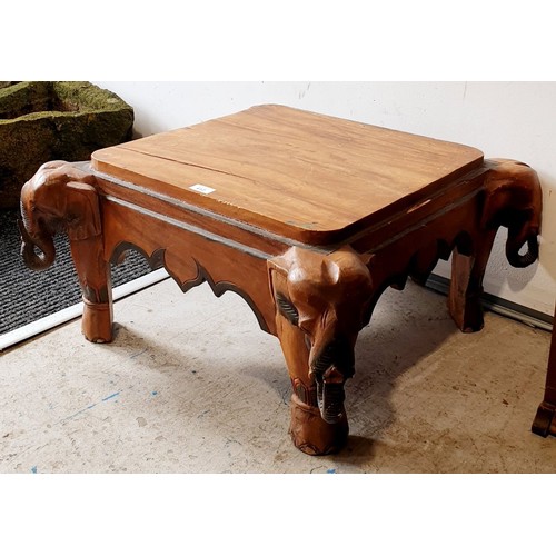 412 - A carved wooden coffee table with elephant's heads at the corners, 27