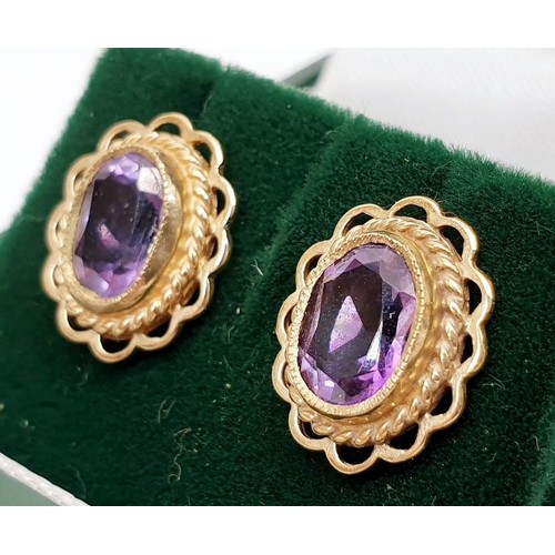 11 - A pair of 9ct gold earrings set with amethyst, weight 1.9g. UK shipping £14.