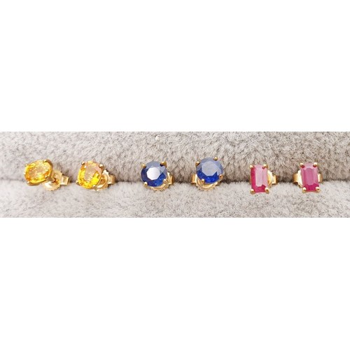 12 - Three pairs of 9ct gold earrings, one set with rubies, one with blue sapphires and one with yellow s... 