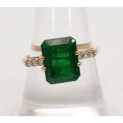 22 - A 9ct gold ring set with an emerald and white stones, gross weight 2.6g, size P. UK shipping £14.