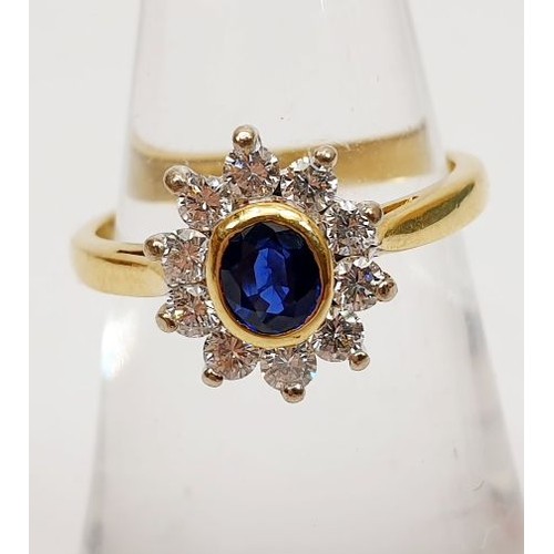 38 - An 18ct gold cluster ring set with diamonds and a sapphire in a rub over setting, gross weight 3.3g,... 