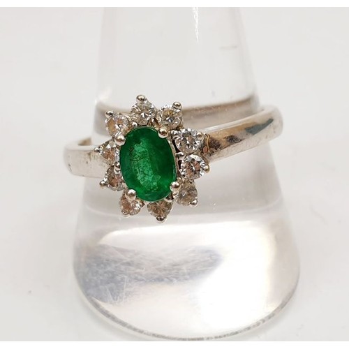 41 - A hallmarked 18ct white gold cluster ring set with diamonds and an emerald, gross weight 7.5g, size ... 