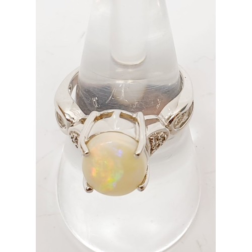 52 - A hallmarked 9ct white gold ring set with an opal and white stones, gross weight 4.8g, size N/O. UK ... 