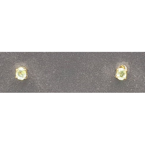 49 - A pair of hallmarked 18ct gold earrings set with tourmalines, gross weight 1.3g. UK shipping £14.