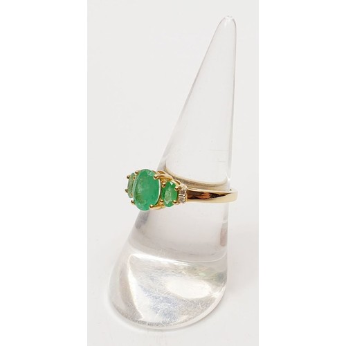 54 - A hallmarked 9ct gold three stone emerald ring, size O, gross weight 2.8g. UK shipping £14.