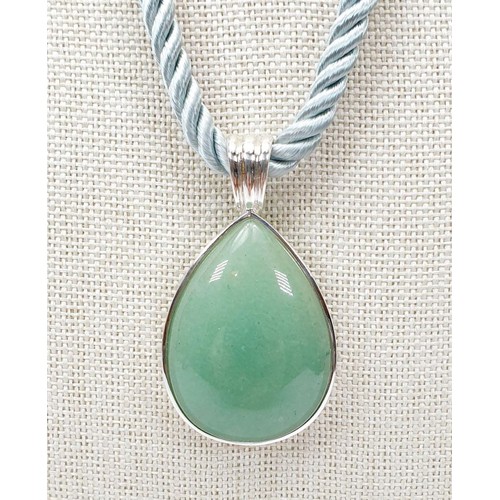 56 - A silver pendant set with green hardstone on a silk and silver hanger. UK shipping £14.