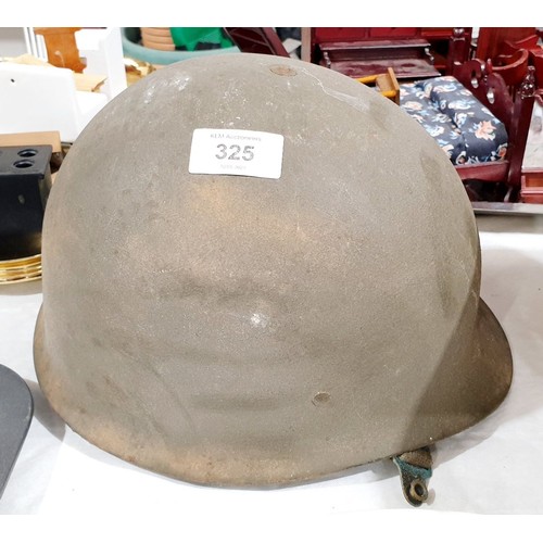 325 - A vintage military helmet. UK shipping £14.