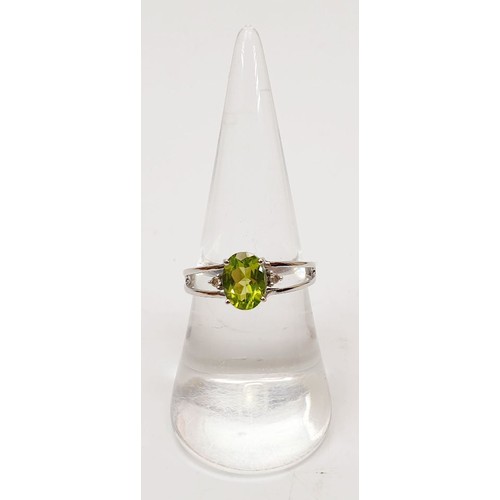 34 - A hallmarked 9ct white gold ring set with peridot and diamond, size O, gross weight 1.8g. UK shippin... 