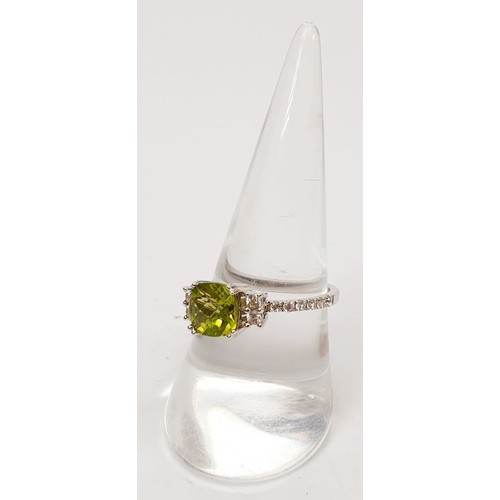 63 - A platinum plated silver ring set with peridot and zircon, size Q. UK shipping £14.