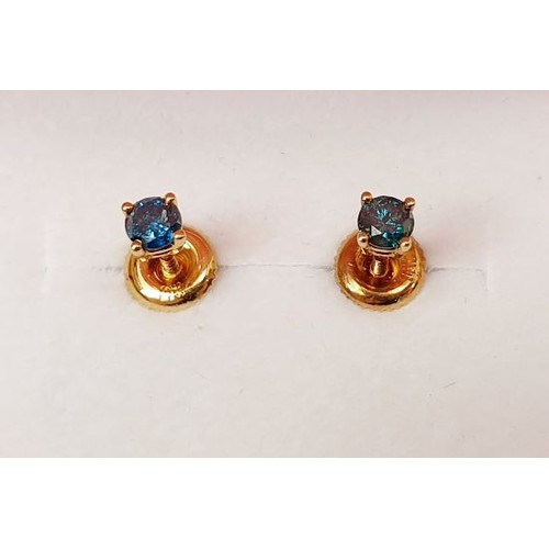 37 - A pair of hallmarked 14ct earrings set with teal-blue diamond and having screw backs. UK shipping £1... 