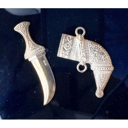 72 - A miniature silver dagger and sheath mounted in a frame, 7