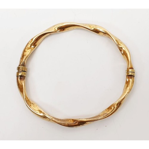 12 - A 9ct gold hollow bangle, weight 7.3g. UK shipping £14.