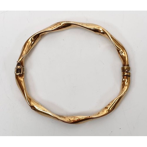 12 - A 9ct gold hollow bangle, weight 7.3g. UK shipping £14.