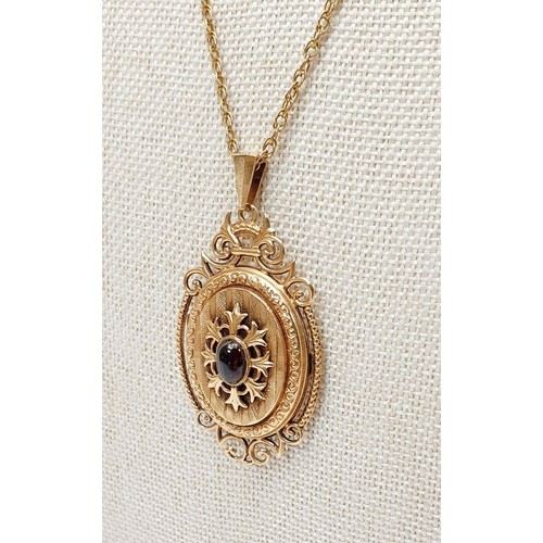 15 - A hallmarked 9ct gold locket set with a cabochon cut garnet on a yellow metal chain, gross weight 8g... 