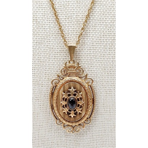 15 - A hallmarked 9ct gold locket set with a cabochon cut garnet on a yellow metal chain, gross weight 8g... 