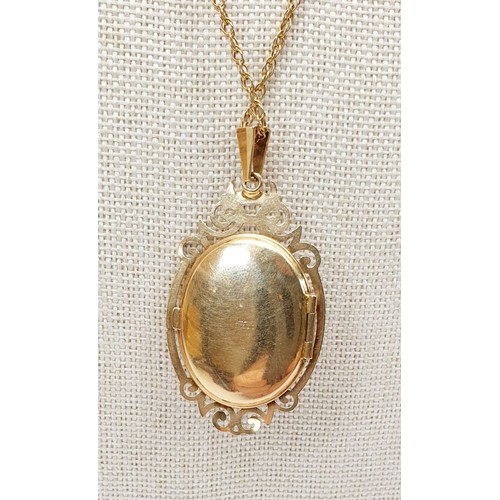 15 - A hallmarked 9ct gold locket set with a cabochon cut garnet on a yellow metal chain, gross weight 8g... 