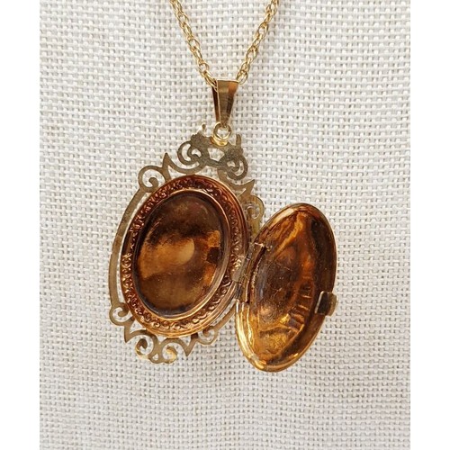 15 - A hallmarked 9ct gold locket set with a cabochon cut garnet on a yellow metal chain, gross weight 8g... 