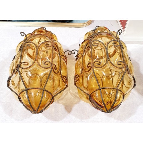 58 - A pair of amber glass lanterns bound with wire, length 12