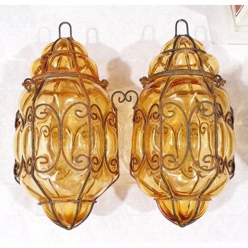 58 - A pair of amber glass lanterns bound with wire, length 12