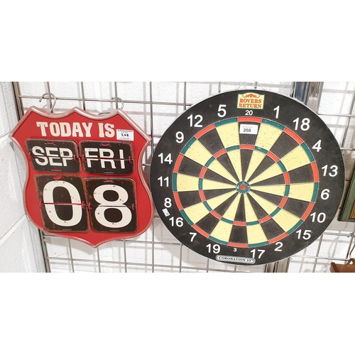 208 - A Coronation St. Rover's Return branded dartboard together with a tin American road sign calendar. N... 