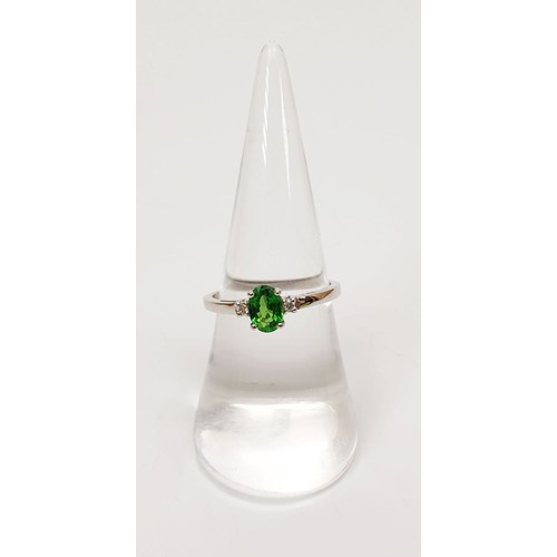 16 - A hallmarked 18ct white gold tsavorite and diamond ring, gross weight 2g, size N/O. UK shipping £14.