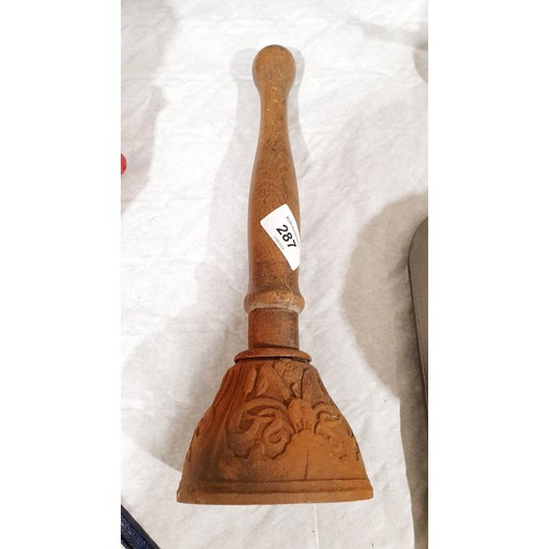 287 - An early 20th century cast iron and wooden hand bell, length 12