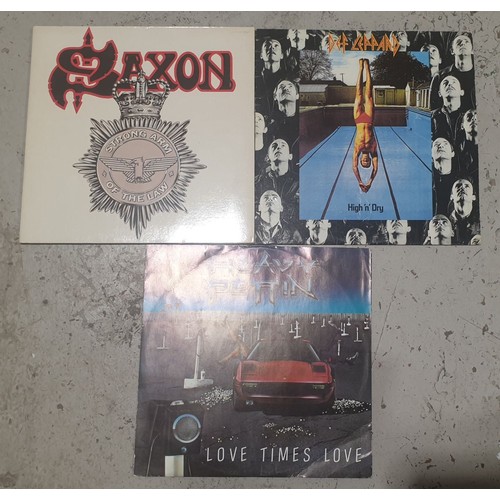 64 - Two LPs: Saxon Strong Arm of the Law and Def Leopard Hi 'n' Dry together with a Heavy Pettin 12