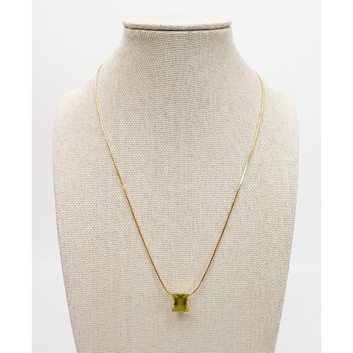 23 - An 18ct gold pendant set with a peridot on an 18ct gold chain, chain length 18