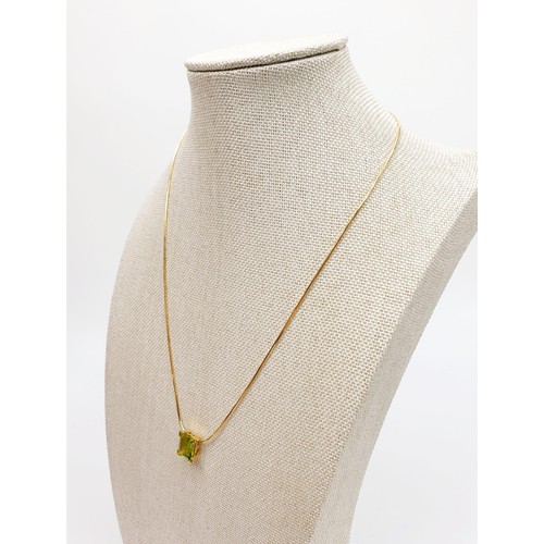 23 - An 18ct gold pendant set with a peridot on an 18ct gold chain, chain length 18