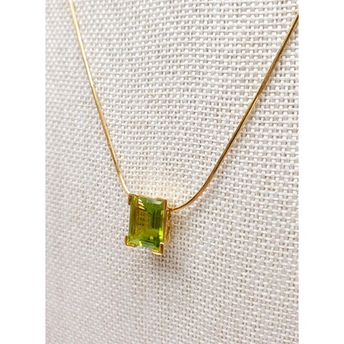 23 - An 18ct gold pendant set with a peridot on an 18ct gold chain, chain length 18