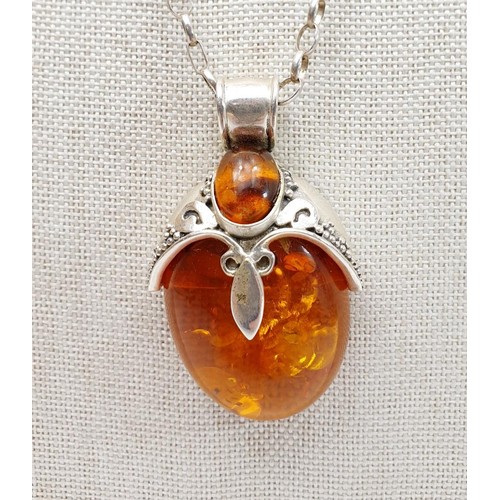 35 - A silver and amber pendant in the form of a beetle on a silver chain, chain length 18