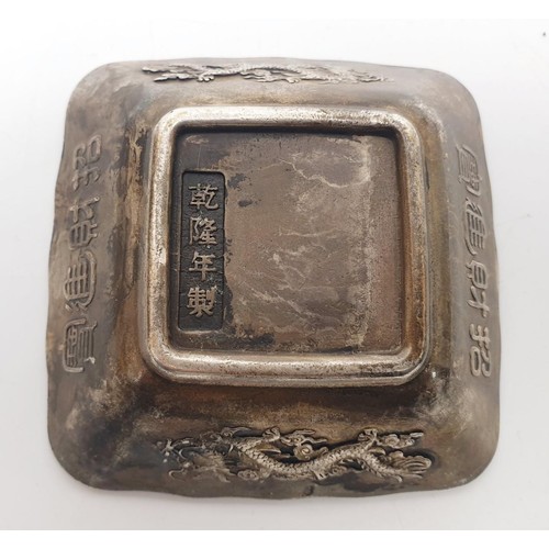 329 - A Chinese metal dish embossed with dragons and Buddhist symbols, a signature to the base, 3